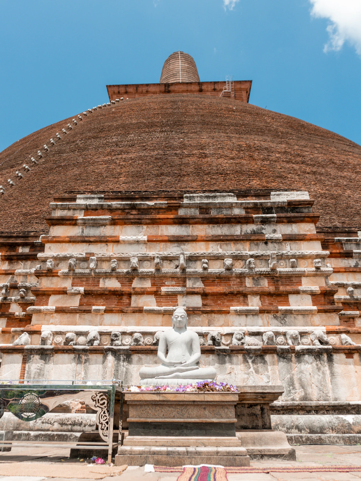 A large stone structure with a buddha statue in front of it